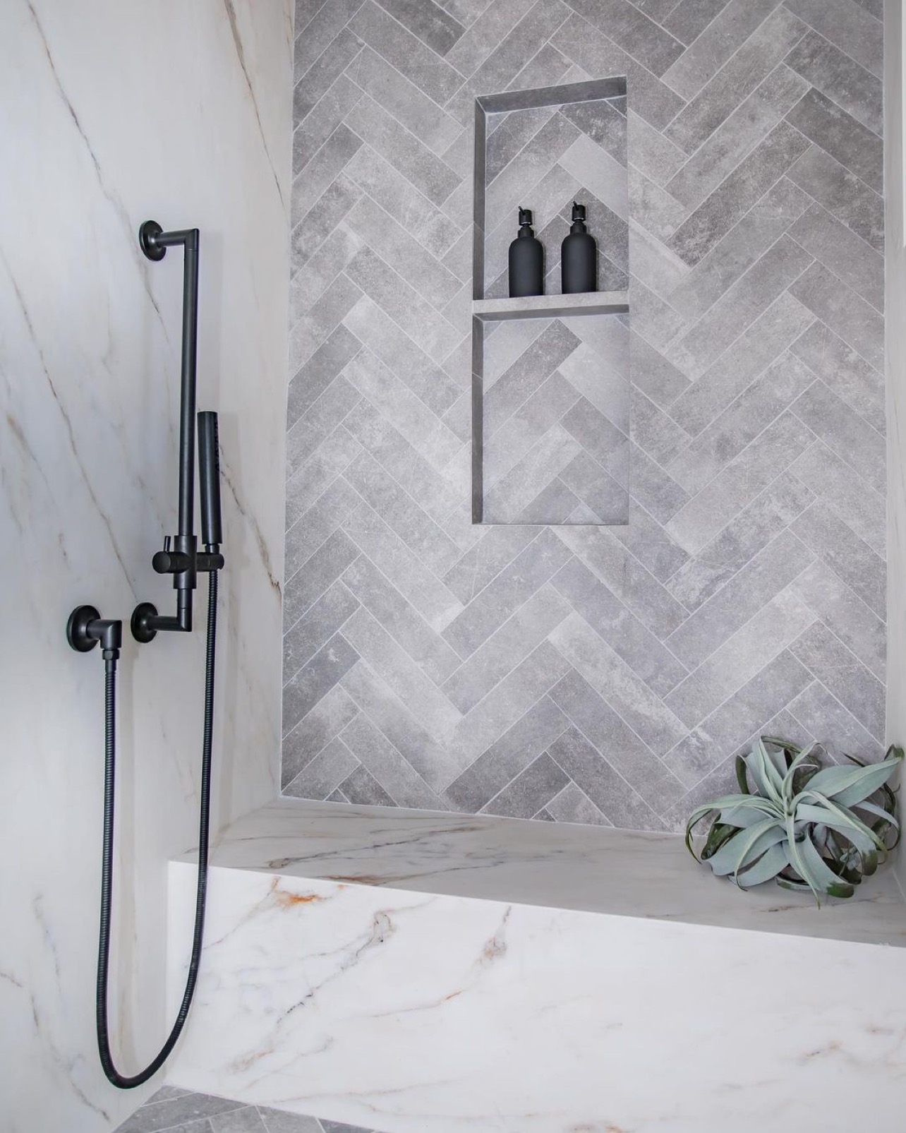 Oversized shower bench seat and herringbone tile accent wall