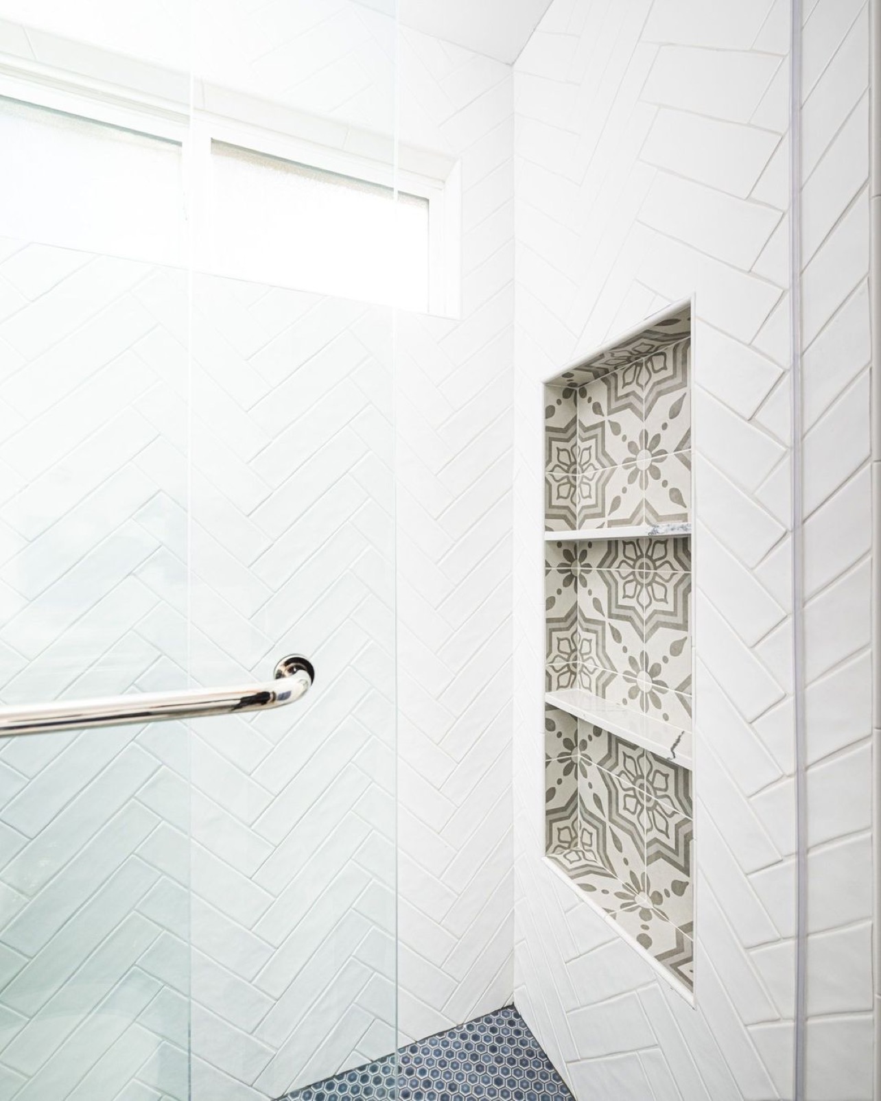 White subway tile with a pop of color and pattern in the shampoo niche